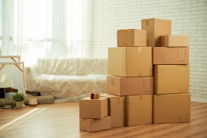 shot room interior with package boxes standing middle sofa covered with film